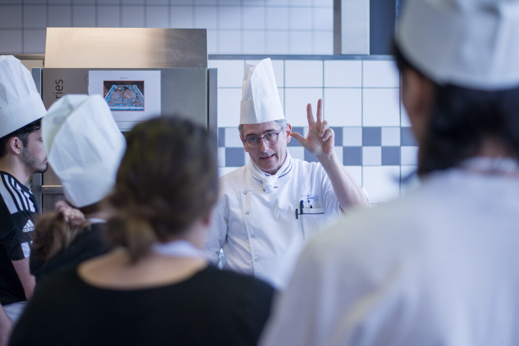Die Lehrperson erklärt den Lernenden: In der Profiküche zählen klare Grundsätze und wer hier einsteigen will, lernt sie eindrücklich kennen.