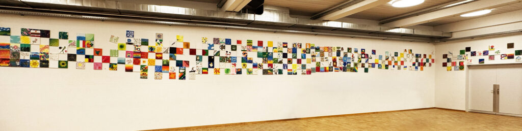 Das Foto zeigt die grösste freie Wand in der Aula der BFF mit den 292 Bildern der Mitarbeitenden.