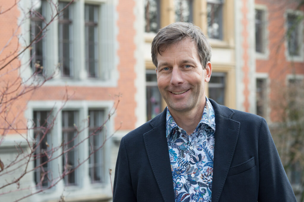 Das Bild zeigt den Abteilungsleiter Jan Denier vor dem Schulgebäude der Berufsbildung