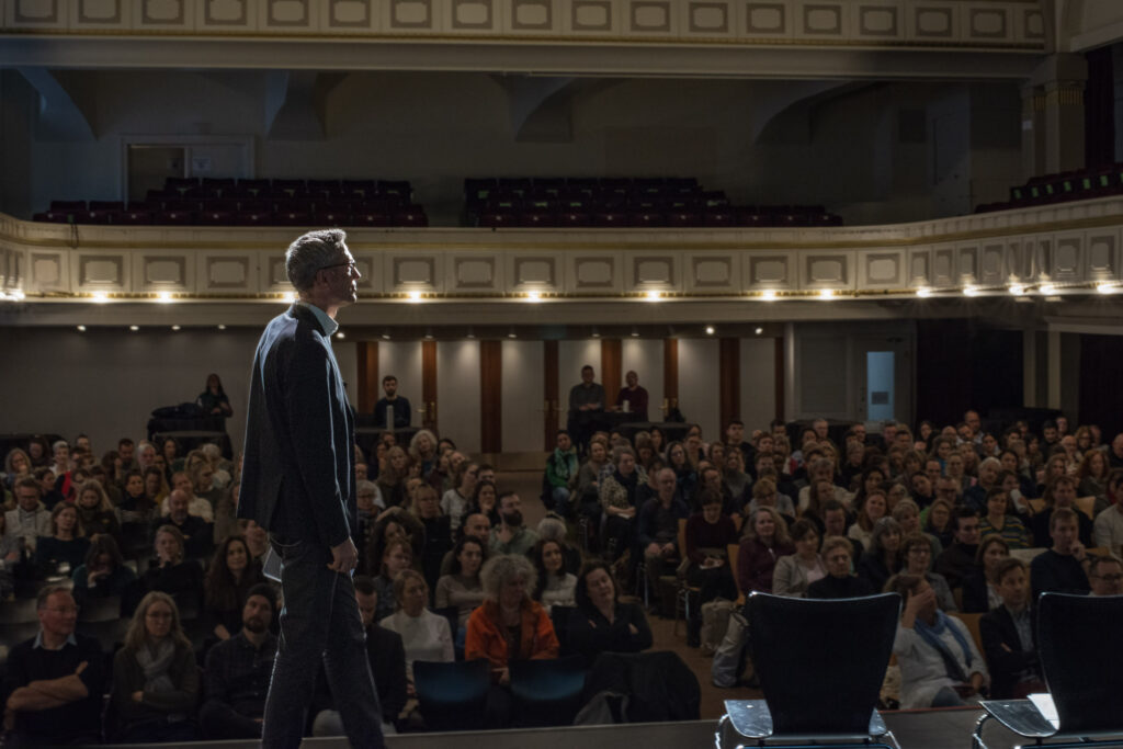 Das Bild zeigt Thomas Althaus im gefüllten Saal des National