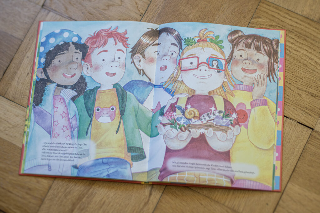 Das Bild zeigt eine bunt illustrierte Doppelseite des Buchs.